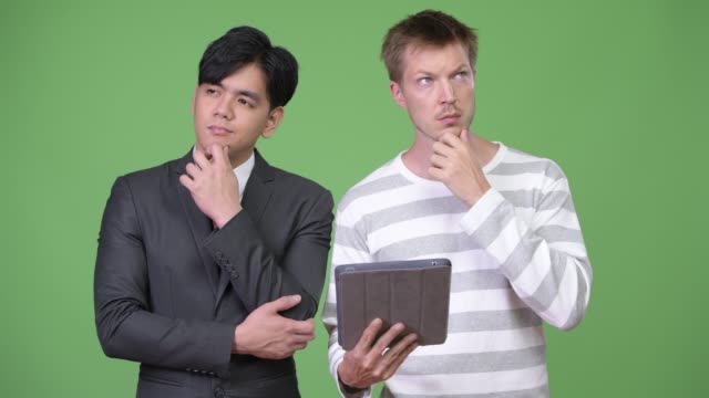 Young-handsome-Asian-businessman-and-young-Scandinavian-businessman-working-together