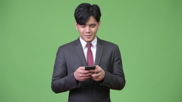 Young-handsome-Asian-businessman-using-mobile-phone