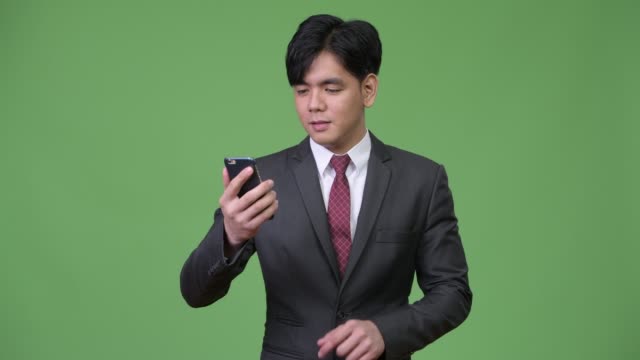Junge-hübsche-asiatische-Geschäftsmann-mit-Handy
