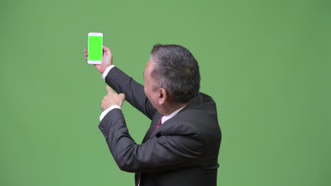 Reife-japanischer-Geschäftsmann-zeigen-Telefon-mit-Kamera