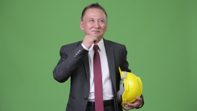 Reife-japanischer-Geschäftsmann-als-Ingenieur-denken