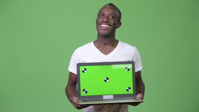 Young-African-man-thinking-while-showing-laptop