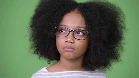Junge-süße-Afrikanische-Mädchen-mit-Afro-Haar-vor-grünem-Hintergrund