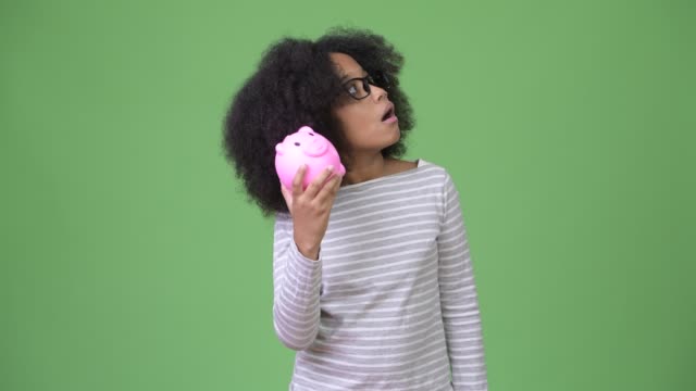 Young-cute-African-girl-with-Afro-hair-holding-piggy-bank