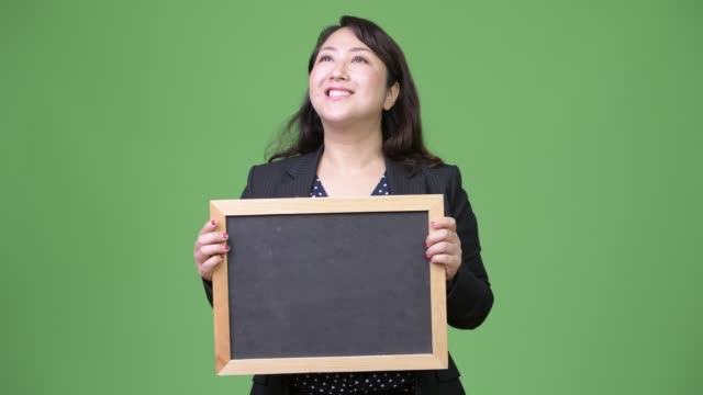 Reife-schöne-asiatische-geschäftsfrau-denken-und-zeigt-Tafel