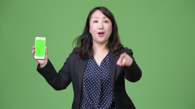 Reife-schöne-asiatische-geschäftsfrau-Telefon-während-Zeigefinger-auftauchen