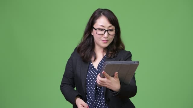 Reife-schöne-asiatische-geschäftsfrau-sucht-schockiert-mit-digital-Tablette