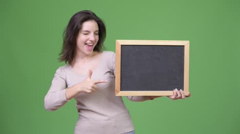 Young-happy-beautiful-woman-giving-thumbs-up-while-holding-blackboard