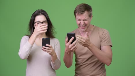 Young-couple-using-phone-and-getting-bad-news-together