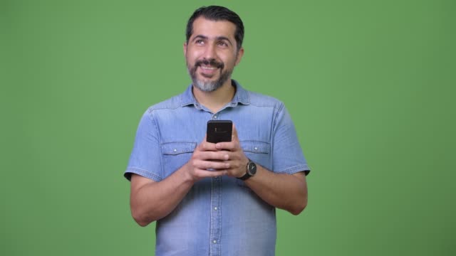 Hübscher-persische-bärtigen-Mann-mit-Handy-und-denken