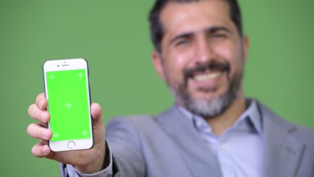 Handsome-Persian-bearded-businessman-showing-phone