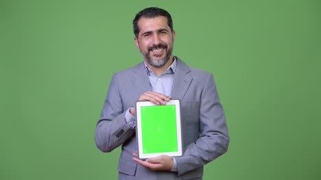 Gut-aussehend-persischen-bärtigen-Geschäftsmann-zeigt-digital-Tablette