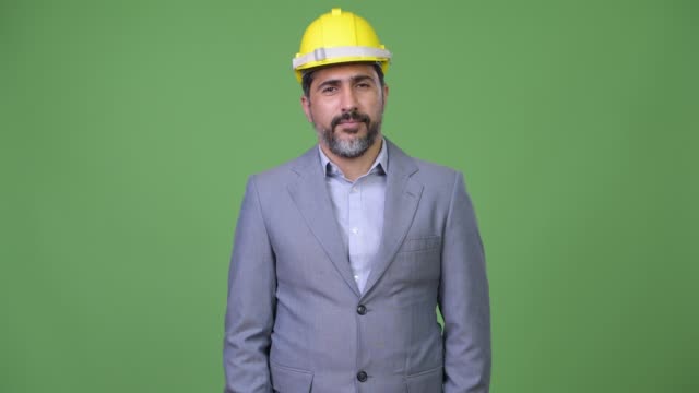 Gut-aussehend-glücklich-persischen-bärtigen-Geschäftsmann-als-Ingenieur-lächelnd