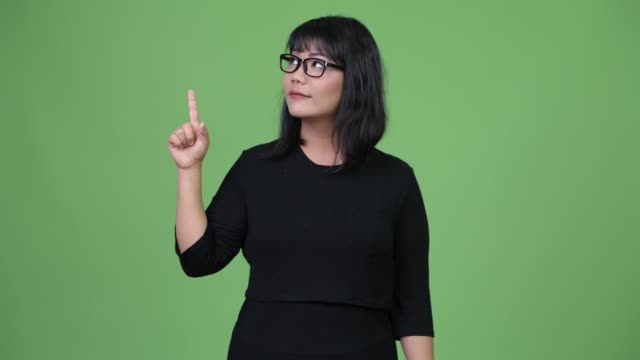 Beautiful-Asian-businesswoman-thinking-while-pointing-finger-up