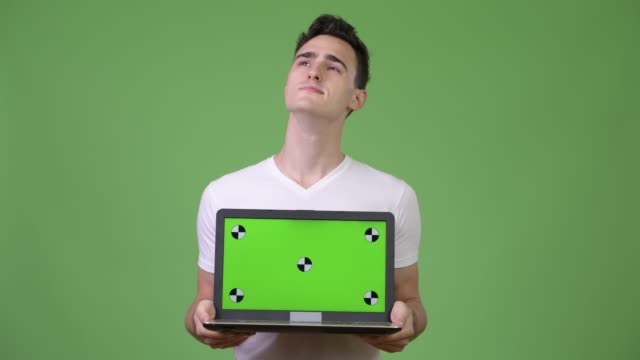 Schönen-jungen-Mann-denken-beim-Laptop-zeigen