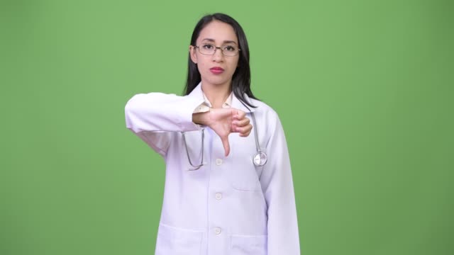 Médico-joven-hermosa-mujer-asiática-dando-pulgares-abajo