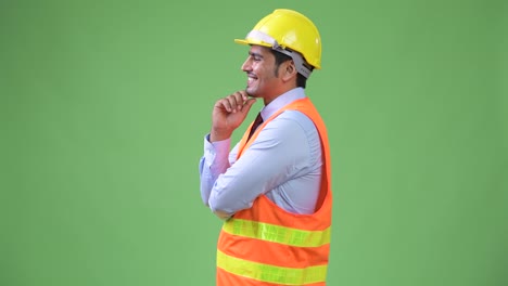 Profile-view-of-young-handsome-Persian-man-construction-worker-thinking