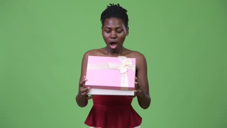 Junge-schöne-Afrikanerin,-die-Geschenkbox-zu-öffnen