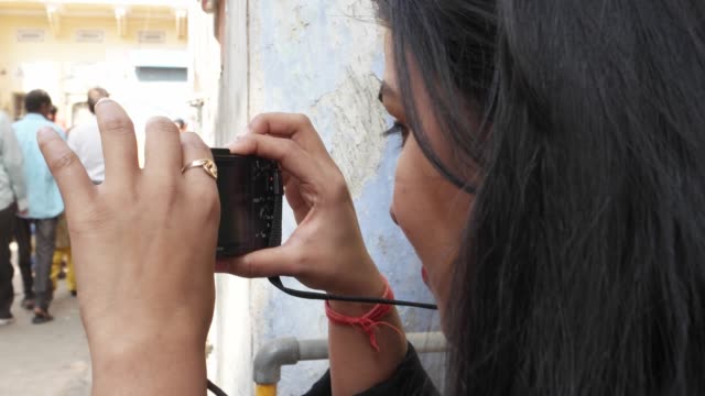 Indische-städtische-Tourist-junge-Frau-nimmt-Fotos-Videos-auf-ihr-point-and-shoot-Kamera-auf-den-Straßen-beschäftigt-corwded