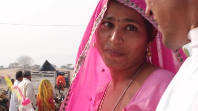 pareja-india-étnica-mano-con-ropa-tradicional-caminando-en-el-recinto-ferial-de-Feria-de-Pushkar,-Rajasthan,-India