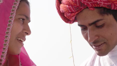 Schönes-Paar-in-Tracht-sprechen-und-Hand-in-Hand-in-Rajasthan,-Indien