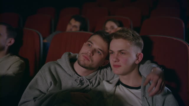 Paar-Homosexuell-umarmen-im-Kino.-Homosexuelle-Männer-umarmen-im-Kino