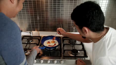 Hombres-gay-comiendo-desayuno-cocina-huevos-en-cocina-casera