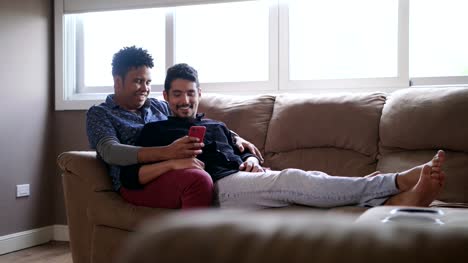Glückliche-Gay-paar-betrachten-von-Bildern-auf-dem-Handy