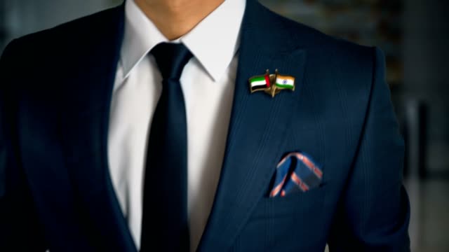 Businessman-Walking-Towards-Camera-With-Friend-Country-Flags-Pin-United-Arab-Emirates---India