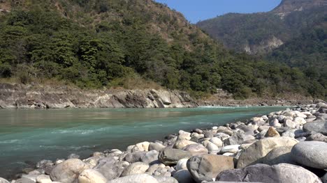Holy-Ganges-river-flowing-among-the-green-mountains-of-Rishikesh,-India.