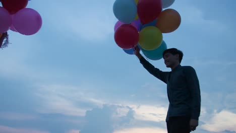Junges-paar-Leute-halten-Ballon-mit-Sonnenuntergang-Hintergrund-in-Zeitlupe.