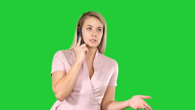 Beautiful-girl-blonde,-speaking-with-someone-on-phone-on-a-Green-Screen,-Chroma-Key