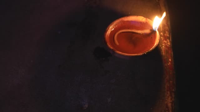 Traditionelle-indische-tönerne-Öllampe-mit-Baumwolldocht-brennen-in-der-Nacht
