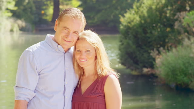 Mature-Couple-Smile-near-a-Pond-in-a-Park