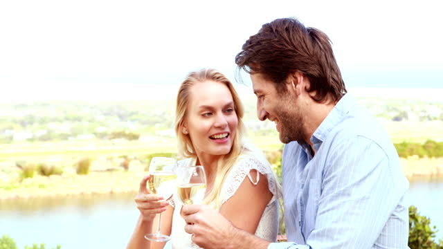 Linda-pareja-Riendo-y-bebiendo-vino-blanco