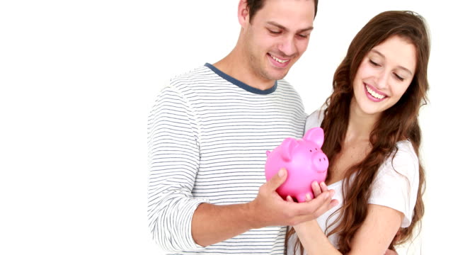 Smiling-couple-holding-piggy-bank