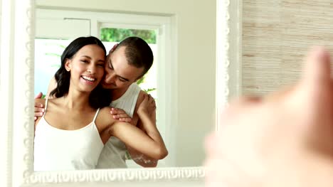 Smiling-young-couple-front-of-mirror