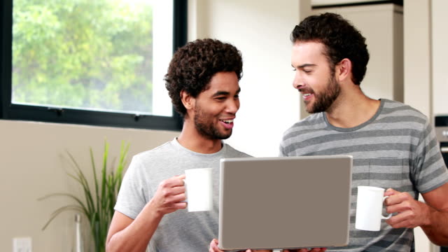 Feliz-pareja-homosexual-usando-ordenador