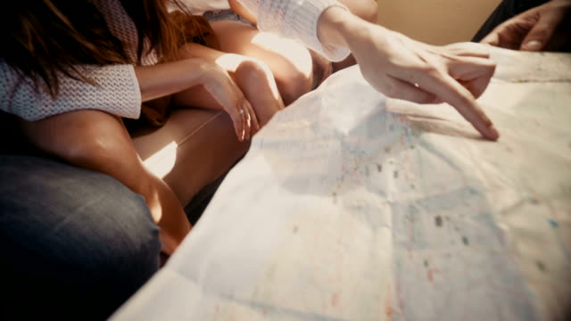 Group-of-young-hipster-friends-looking-at-map-in-vintage-van