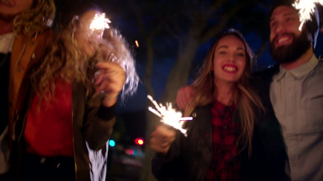 Hipster-Teenager-Freunde-feiern-gemeinsam-mit-Wunderkerzen-bei-Nacht