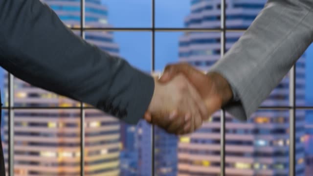Geschäft-Handshake-über-Nacht-Stadt-Hintergrund.