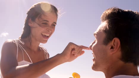 Woman-putting-sunscreen-to-her-boyfriend