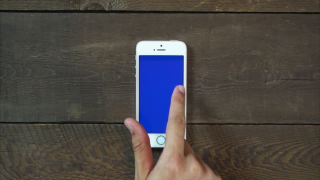 Los-golpes-mano-izquierda-Smartphone-con-pantalla-azul