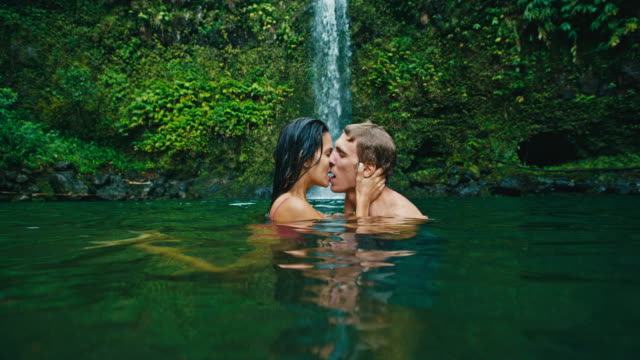 Paar-Küssen-unter-einem-Wasserfall