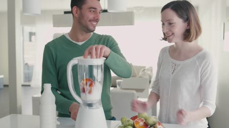 Happy-romantic-couple-are-making-smoothies-in-blender-in-the-kitchen-at-home.