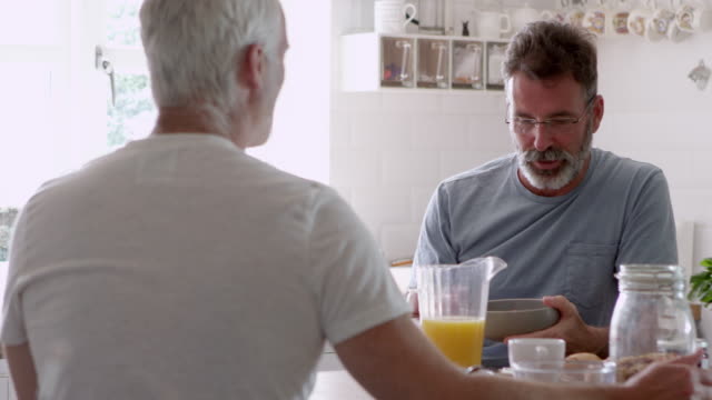 Male-Homosexual-Couple-Having-Breakfast-At-Home-Together