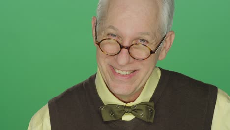 Older-man-with-glasses-shows-an-array-of-emotions,-on-a-green-screen-studio-background