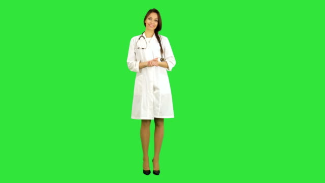 Hermosa-joven-médico-mujer-en-bata-de-laboratorio-con-estetoscopio-mirando-a-la-cámara-en-una-pantalla-verde-Chroma-Key
