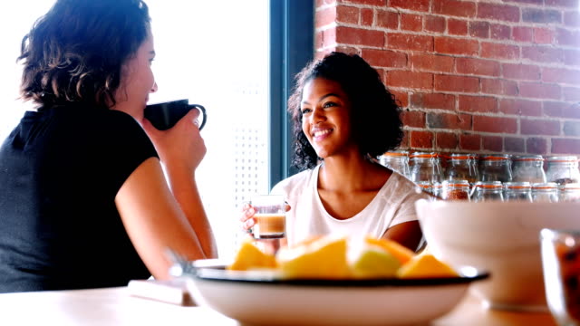 Lesbian-couple-interacting-with-each-other-while-having-breakfast