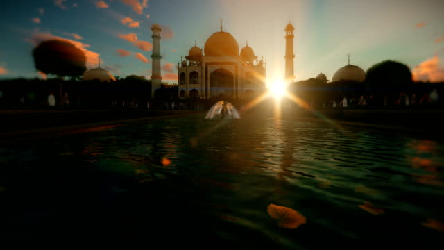 Taj-Mahal-con-turistas-caminando-contra-la-hermosa-puesta-de-sol,-zoom-en-4K